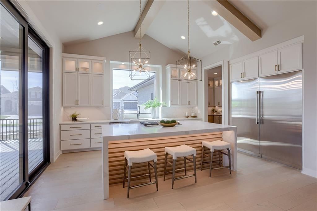 Kitchen island, white kitchen and quartz counters at 13610 Granada Drive, Leawood, KS 66224