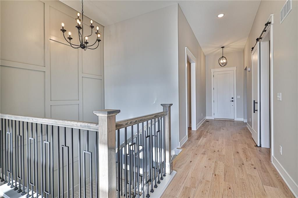 Statement lighting, shiplap / paneling and staircase at 14014 Crawford Creek Circle, Lake Lotawana, MO 64034
