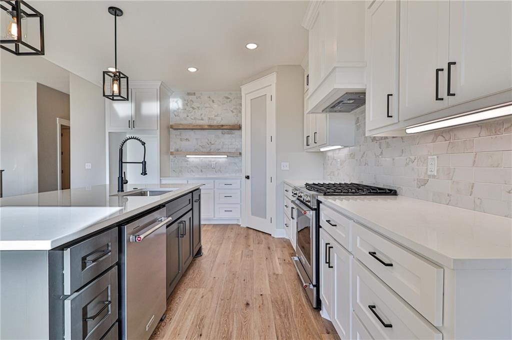 White kitchen, quartz counters and gas range at 14014 Crawford Creek Circle, Lake Lotawana, MO 64034