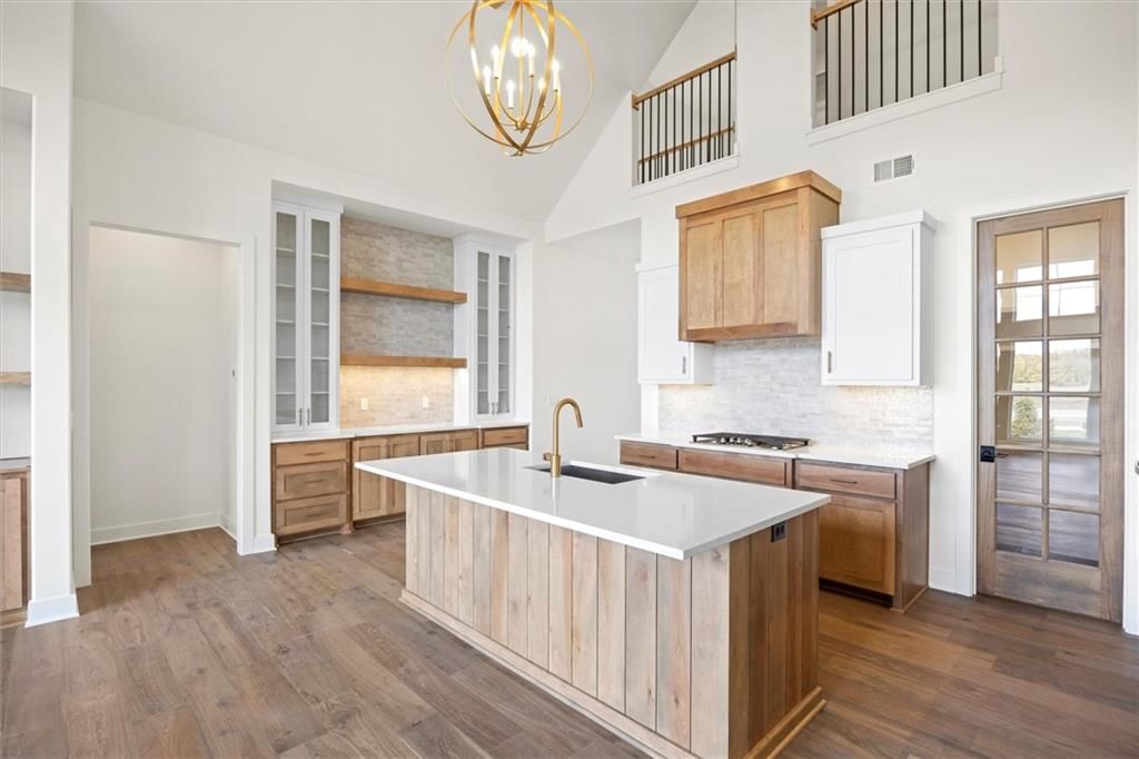 Kitchen island, quartz counters and statement lighting at 17028 Rosehill Street, Overland Park, KS 66221