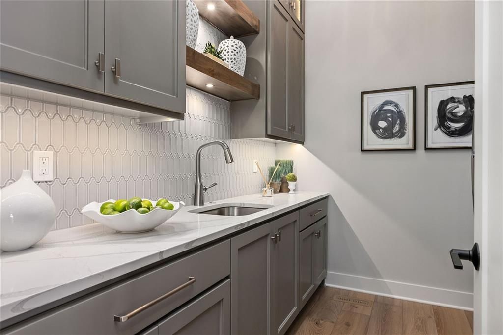 Gray kitchen cabinets and kitchen backsplash at 13701 Guilford Road, Leawood, KS 66224