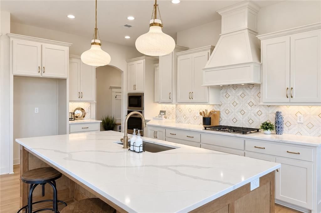 Kitchen island, white kitchen and quartz counters at 8004 Round Prairie Street, Shawnee, KS 66220