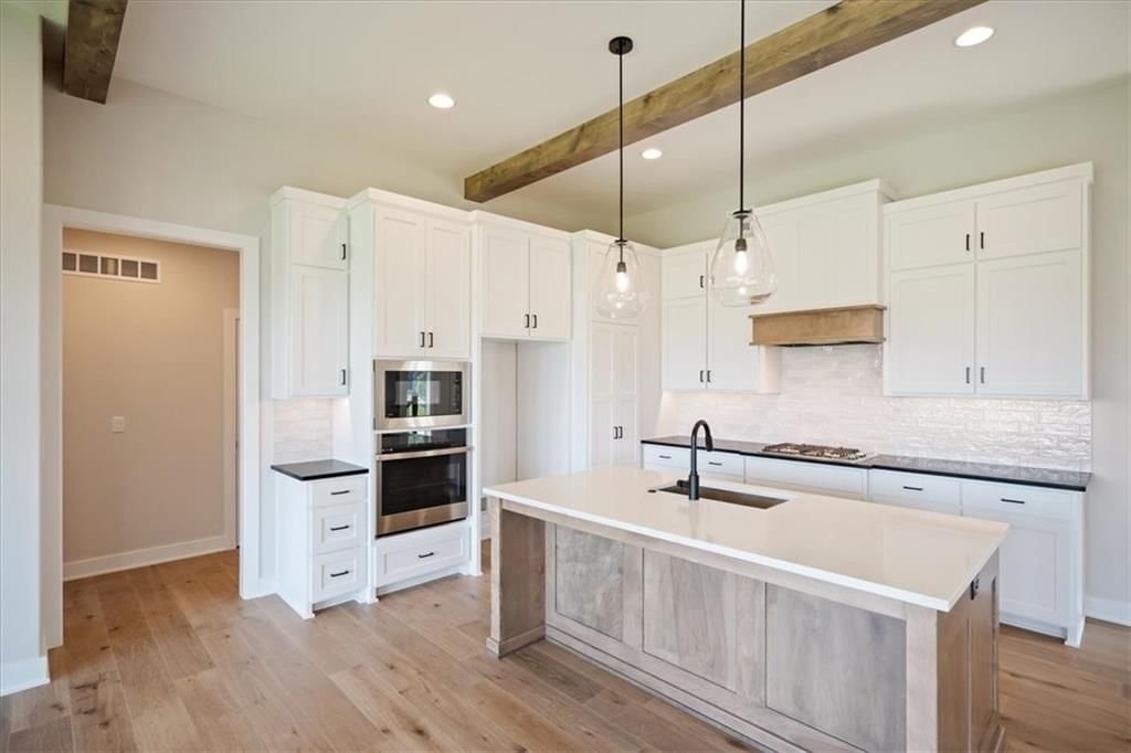 White kitchen, open floor plan and tall ceilings at 2622 SW Barley Field Drive, Lee's Summit, MO 64082