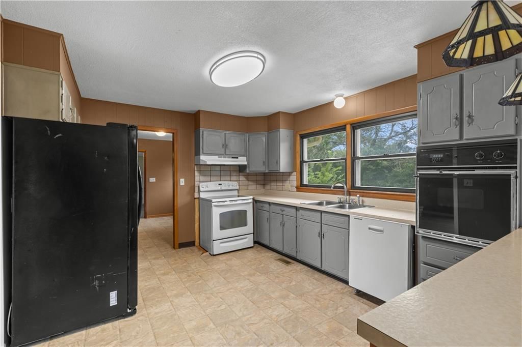 Double oven, electric range and kitchen backsplash at 17029 Springdale Road, Leavenworth, KS 66048