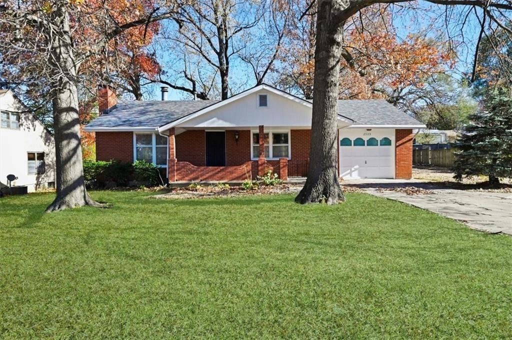 Covered front porch, mature trees and attached garage at 2509 10th Avenue, Leavenworth, KS 66048