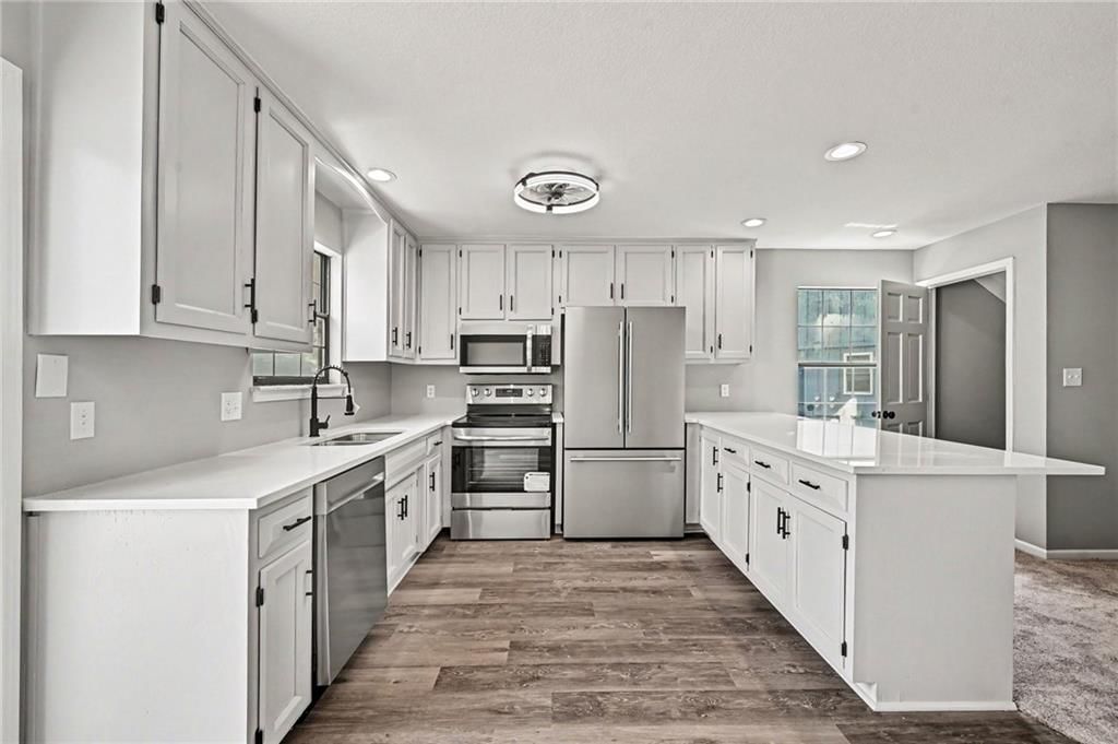 White kitchen, kitchen island and updated kitchen at 7033 N Fisk Court, Kansas City, MO 64151