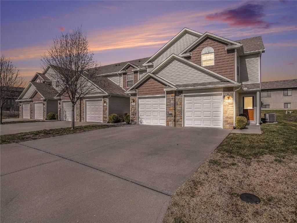 Attached garage and concrete driveway at 254 Pointe Lane, Raymore, MO 64083