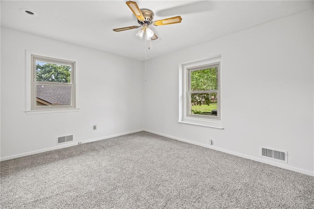 Tiled shower, wainscoting or board and batten and wood vanity at 503 S Park Drive, Raymore, MO 64083