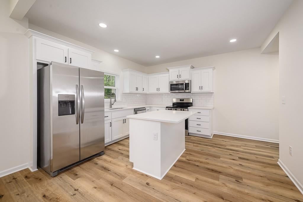 White kitchen, open floor plan and kitchen island at 1122 Randolph Street, Leavenworth, KS 66048