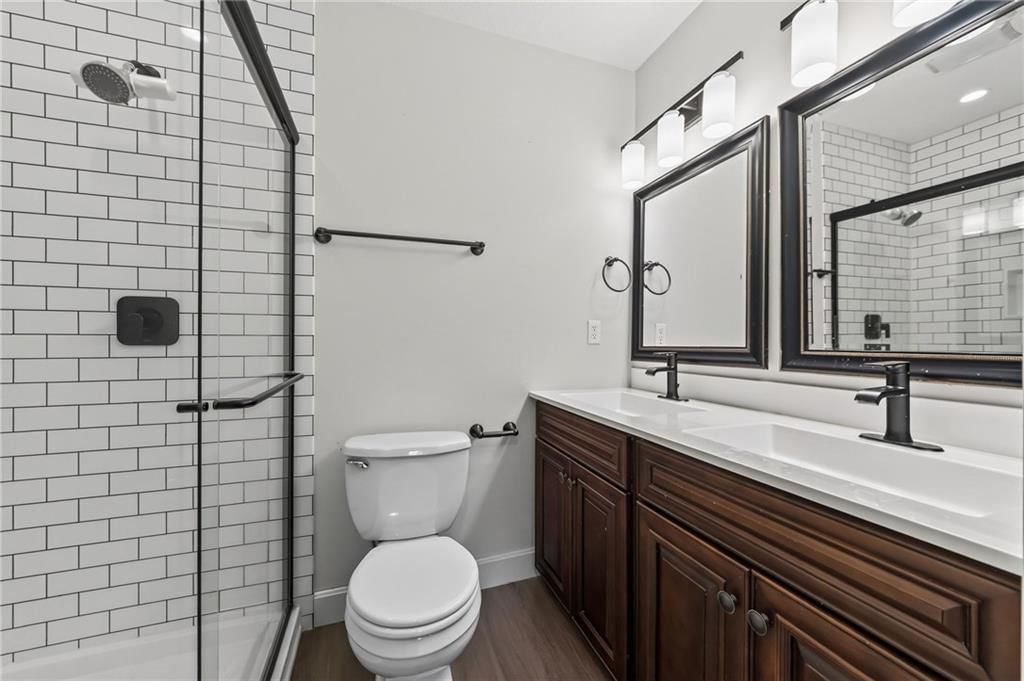 Tiled shower, double vanity and frameless glass shower at 7303 Madison Avenue, Kansas City, MO 64114
