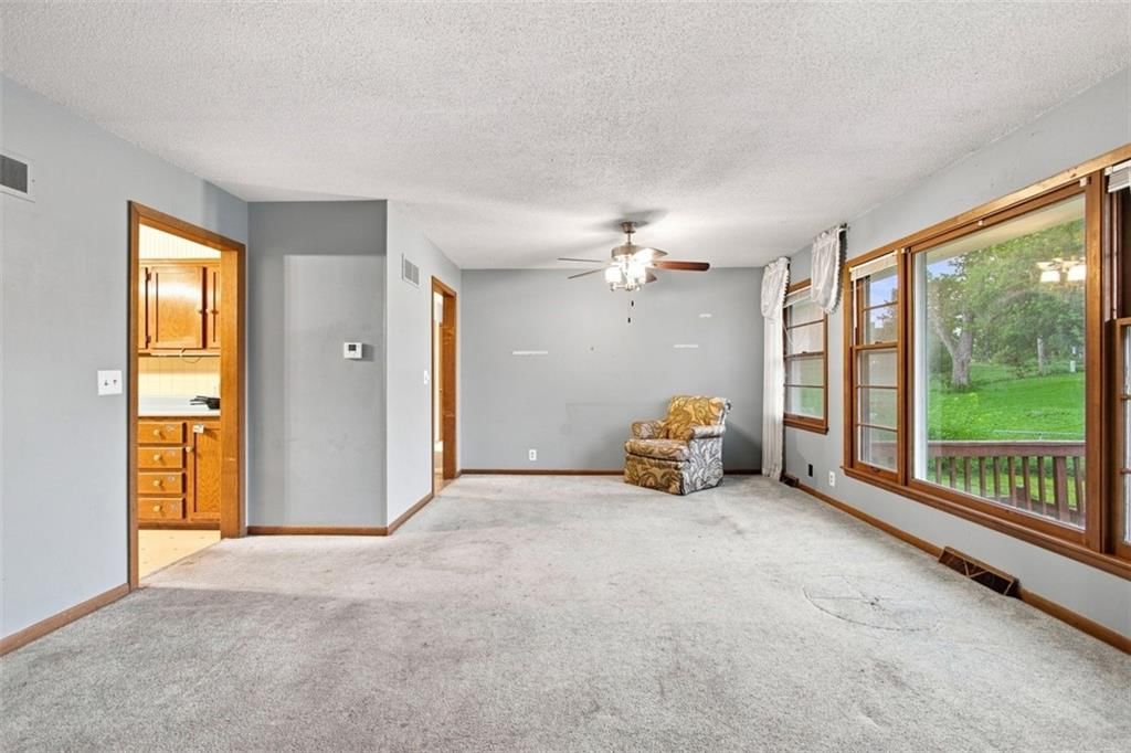 Fireplace, open floor plan and main-floor primary bedroom at 207 Augustus Drive, Excelsior Springs, MO 64024