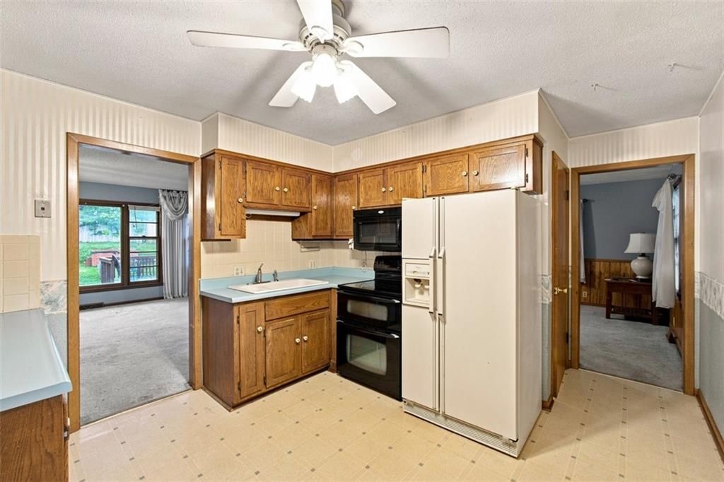 Kitchen island, tray ceiling and breakfast nook at 207 Augustus Drive, Excelsior Springs, MO 64024