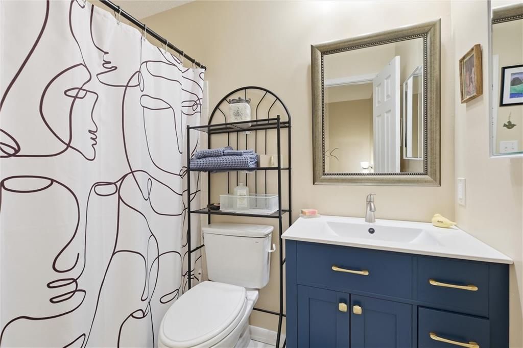 Tiled shower, navy vanity and renovated bathrooms at 9573 Outlook Drive, Overland Park, KS 66207