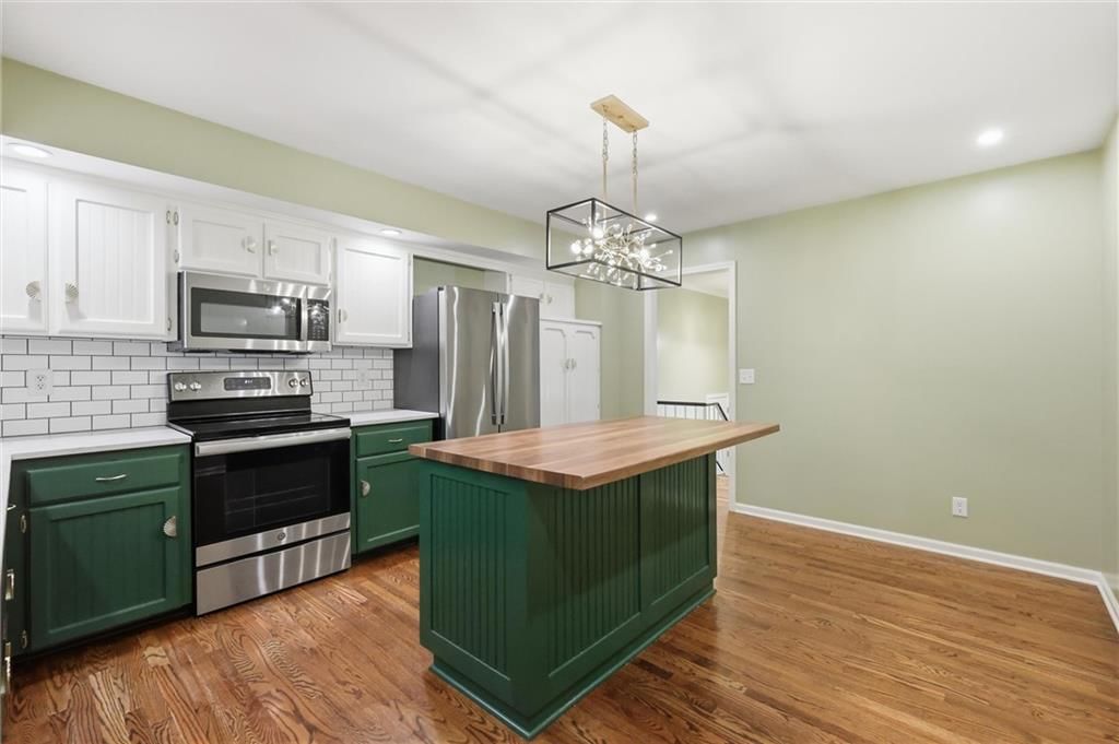Kitchen island, statement lighting and updated kitchen at 5519 NW Verlin Drive, Kansas City, MO 64152