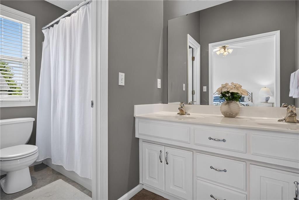 Tiled shower, double vanity and white vanity at 16222 W 157th Terrace, Olathe, KS 66062