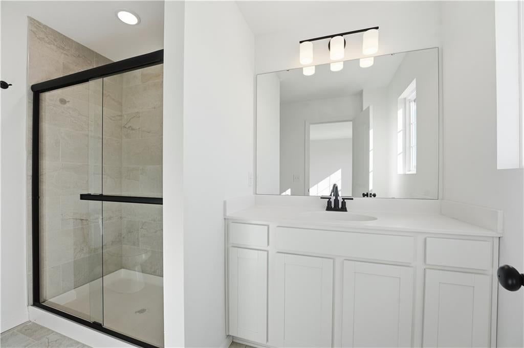 Tiled shower, double vanity and frameless glass shower at 12415 S Acacia Drive, Lake Lotawana, MO 64086