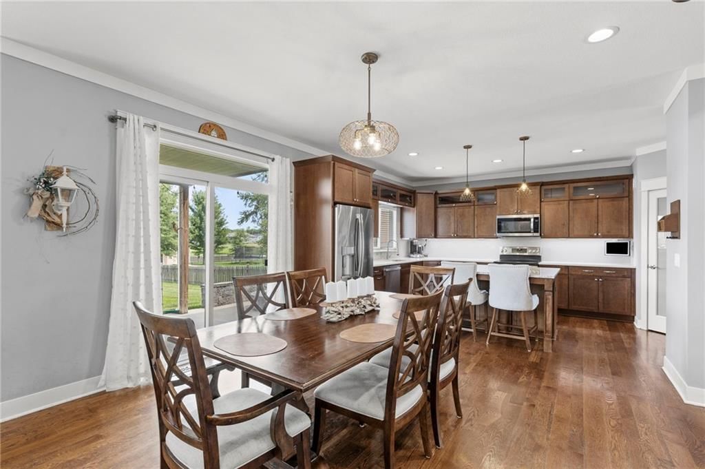 Kitchen island, statement lighting and granite counters at 1800 Knoll Creek Lane, Raymore, MO 64083
