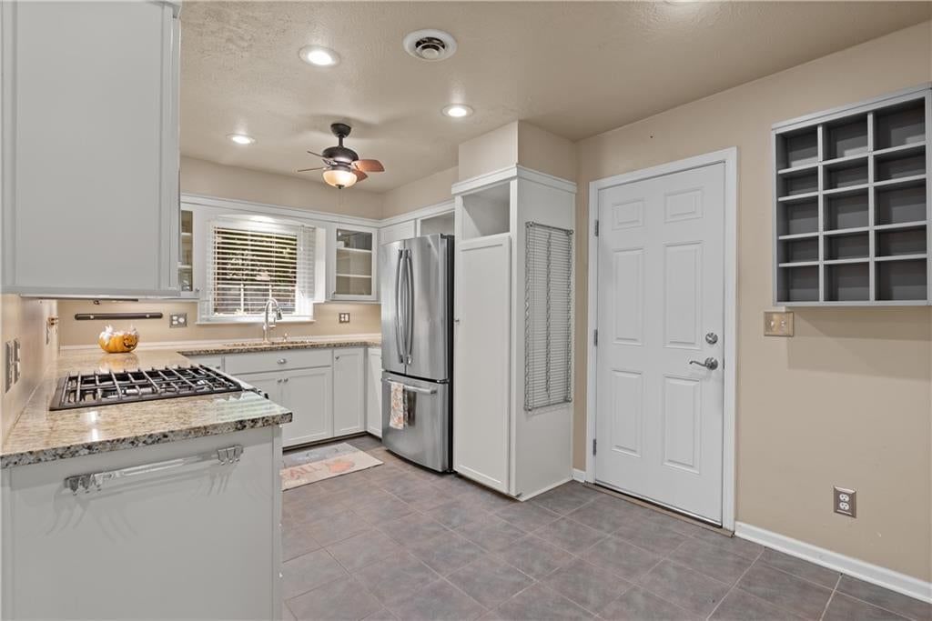 White kitchen, granite counters and tile floors at 1506 SW 6th Street, Lee's Summit, MO 64081
