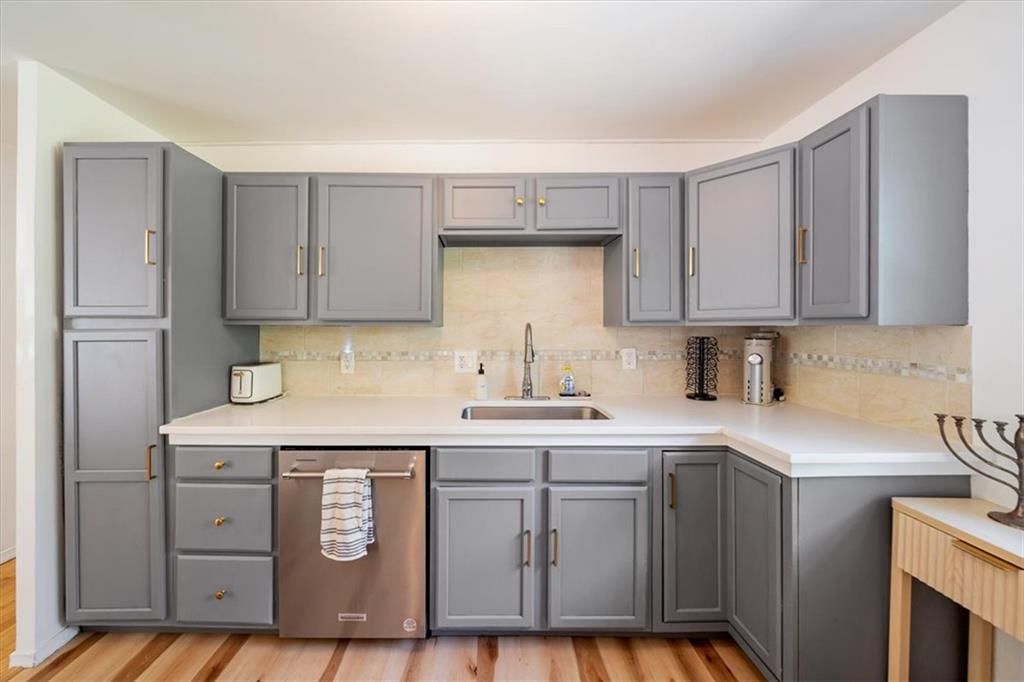 Kitchen island, quartz counters and gray kitchen cabinets at 8506 E 91st Street, Kansas City, MO 64138