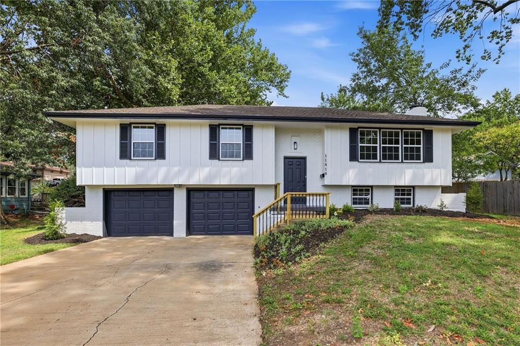 Mature trees, black window frames and attached garage at 11818 E 62nd Terrace, Kansas City, MO 64133