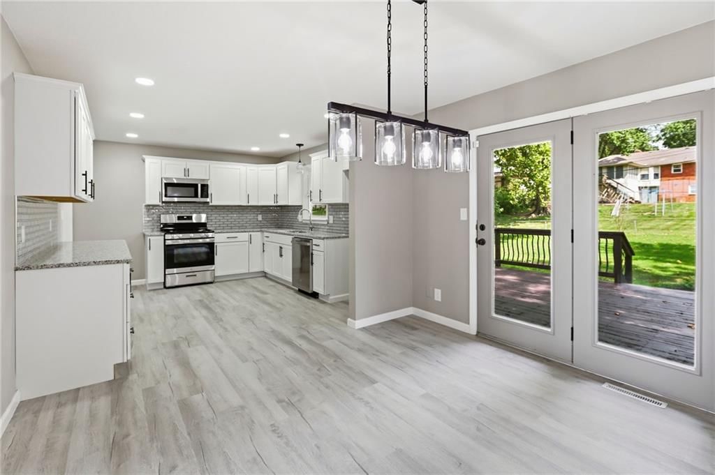 Kitchen island, white kitchen and granite counters at 11818 E 62nd Terrace, Kansas City, MO 64133
