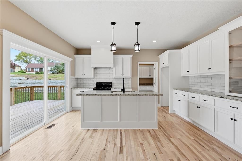 Kitchen island, white kitchen and statement lighting at 7402 Palmer Avenue, Kansas City, MO 64133