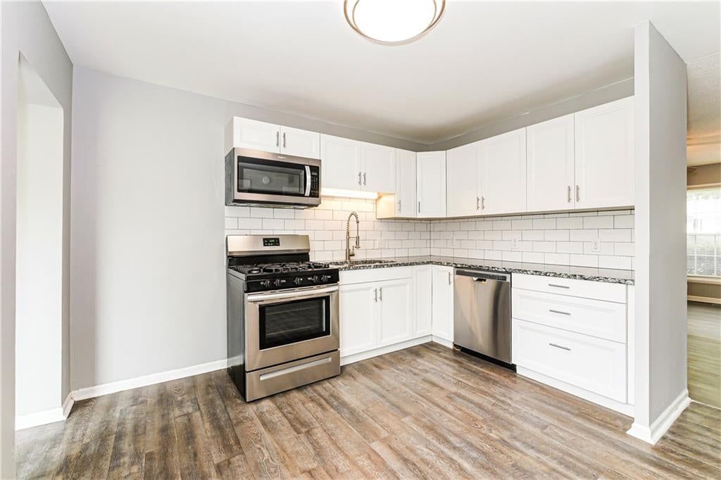 Open floor plan, white kitchen and granite counters at 807 N Ponca Drive, Independence, MO 64056