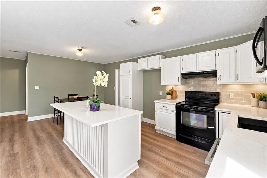 Open floor plan, kitchen island and white kitchen at 209 Main Street, Bucyrus, KS 66013
