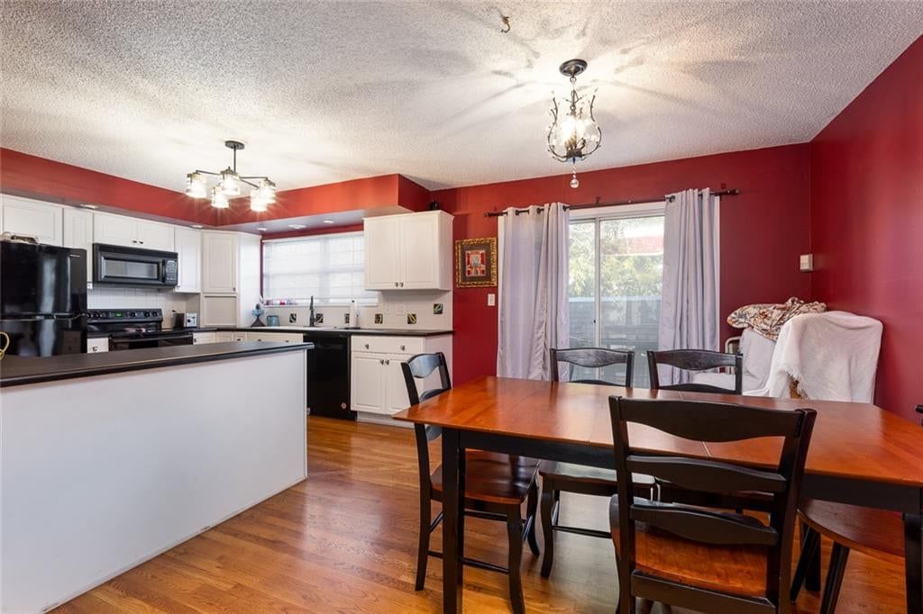 Kitchen island, white kitchen and statement lighting at 10804 Glenwood Street, Overland Park, KS 66211