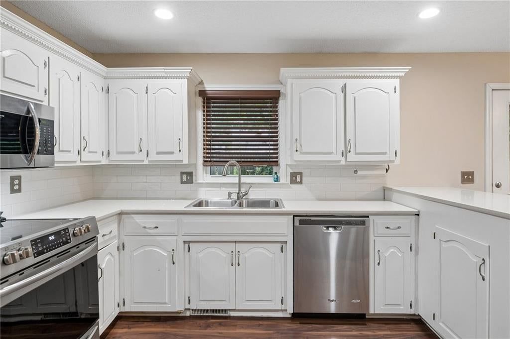 Kitchen island, quartz counters and stainless steel appliances at 7317 NW 77th Terrace, Kansas City, MO 64152