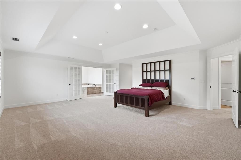 Main-floor primary bedroom, wainscoting or board and batten and coffered ceiling at 16199 Overbrook Lane, Stilwell, KS 66085