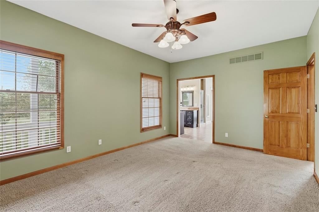 Main-floor primary bedroom, tile floors and freestanding tub at 3930 W 223 Street, Bucyrus, KS 66013
