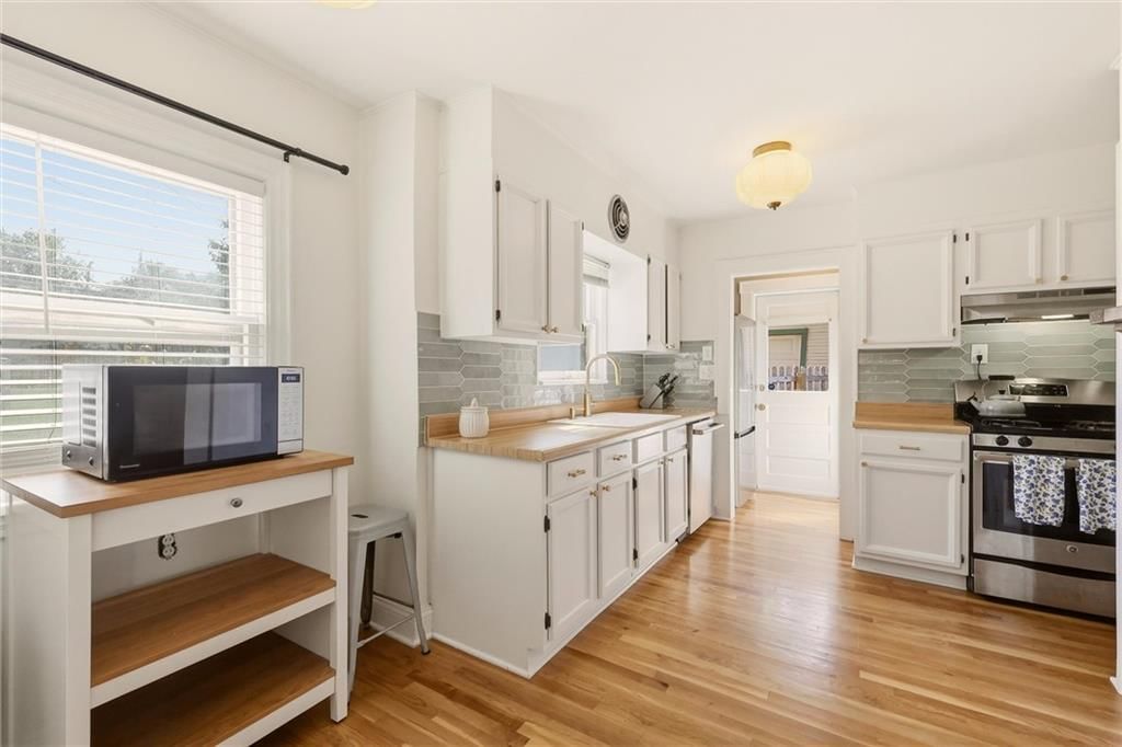 White kitchen, butcher block countertops and stainless steel appliances at 405 E Gregory Boulevard, Kansas City, MO 64131