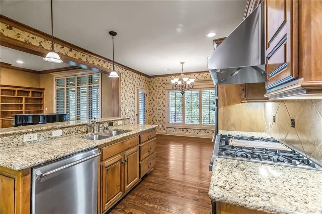 Open floor plan, kitchen island and exposed brick wall at 5303 W 124th Court, Overland Park, KS 66209