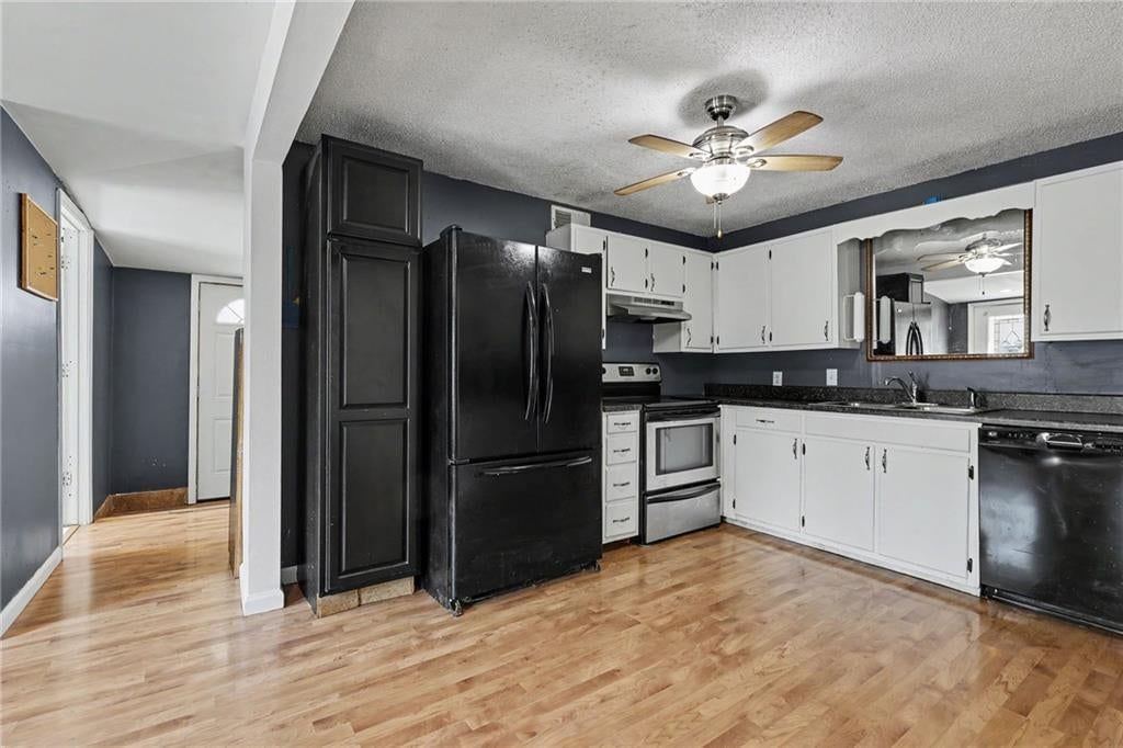 Open floor plan, hardwood floors and white kitchen at 23460 Interurban Road, Dearborn, MO 64439