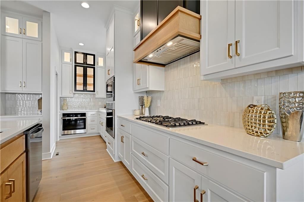 White kitchen, quartz counters and gas range at 24980 W 98th Place, Lenexa, KS 66227