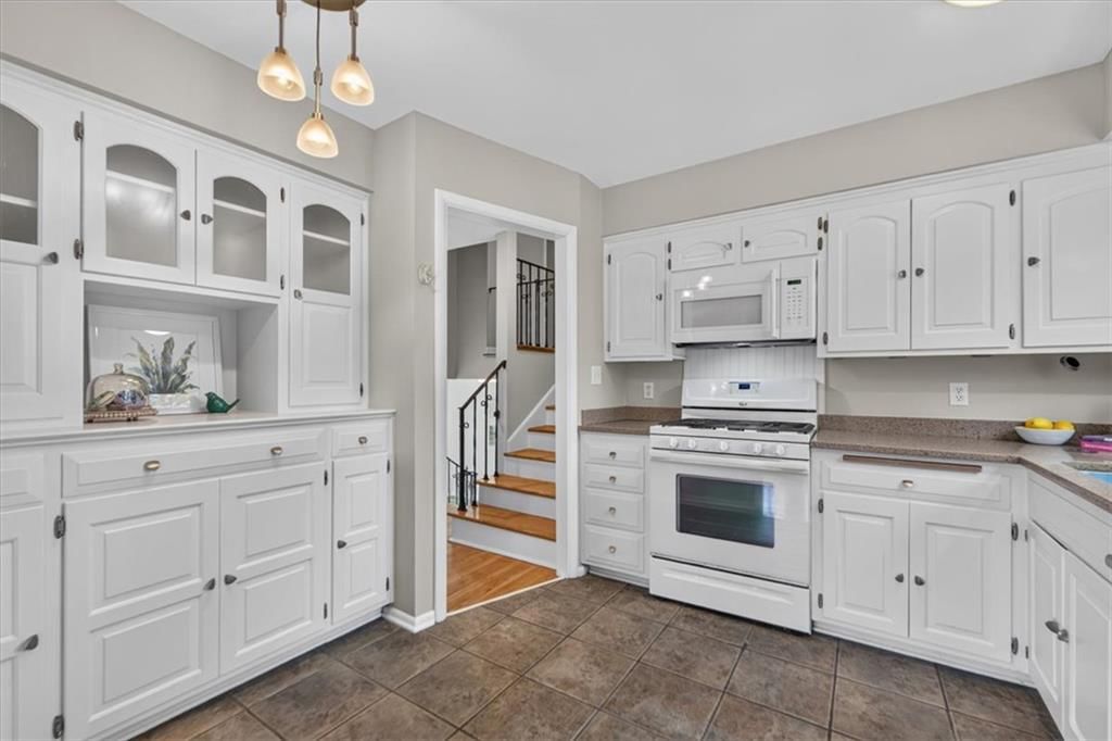 White kitchen, gas range and butcher block countertops at 6324 Robin Hood Drive, Merriam, KS 66203
