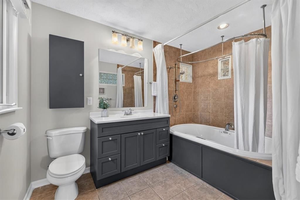 Freestanding tub, tiled shower and frameless glass shower at 6324 Robin Hood Drive, Merriam, KS 66203