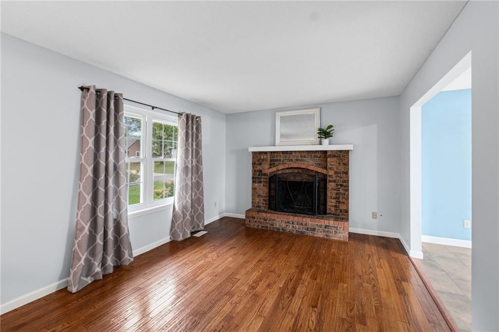 Fireplace, hardwood floors and brick fireplace at 10517 N McGee Street, Kansas City, MO 64155