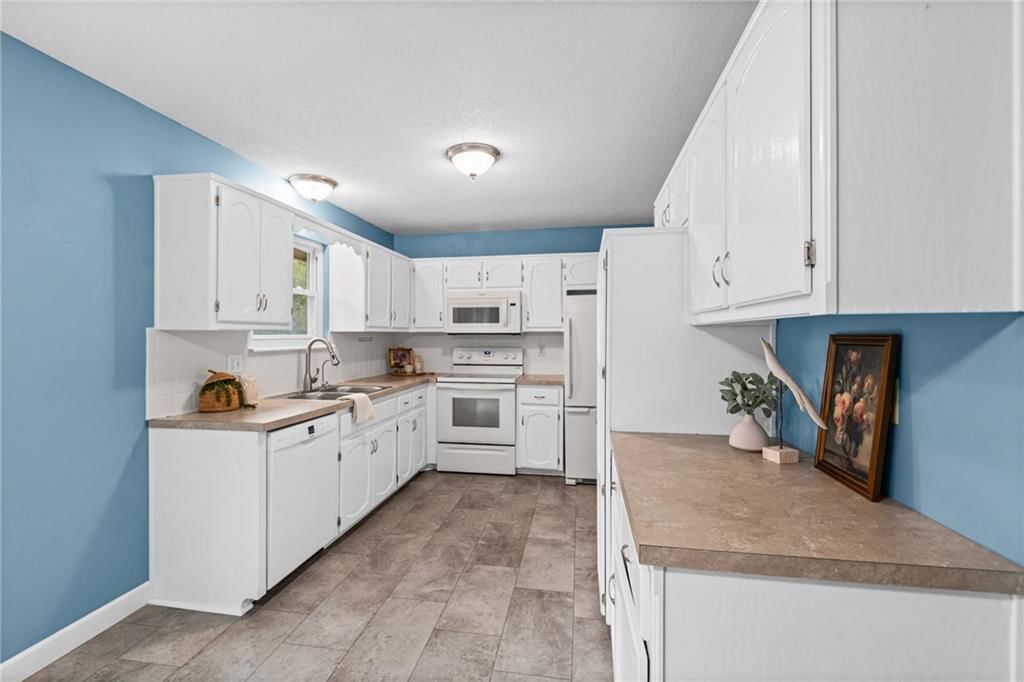 White kitchen, white appliances and electric range at 10517 N McGee Street, Kansas City, MO 64155