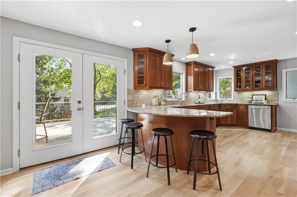 Kitchen island, granite counters and gas range at 13203 W 76th Street, Lenexa, KS 66216