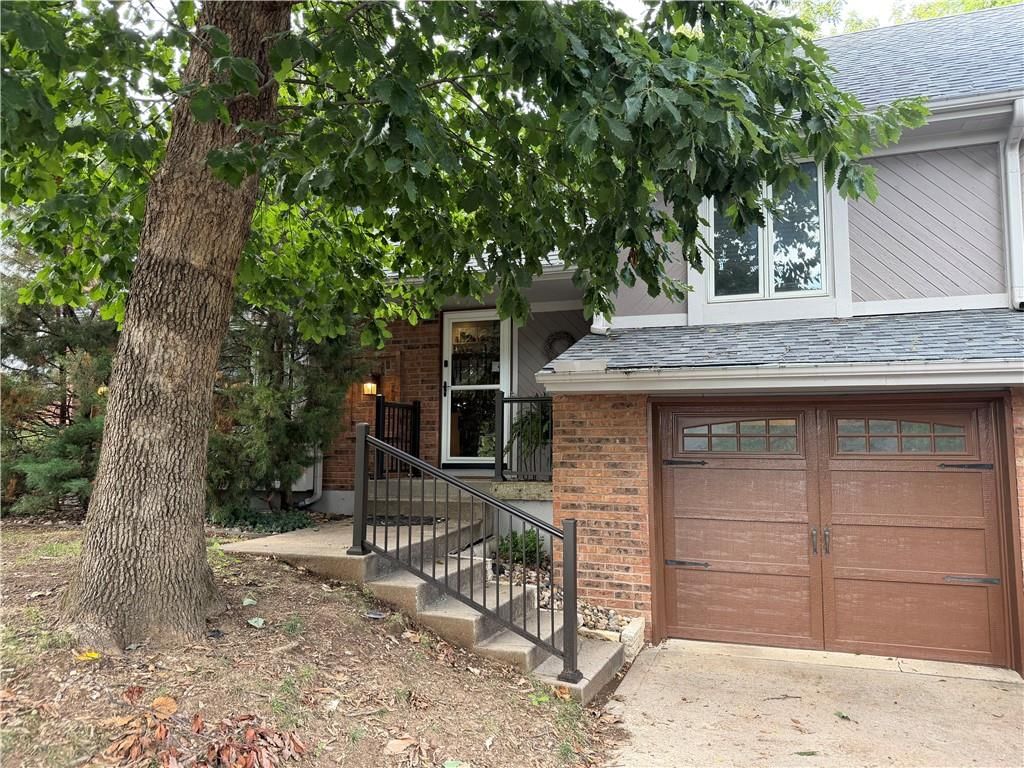 Covered front porch, mature trees and attached garage at 5336 NW 59th Terrace, Kansas City, MO 64152