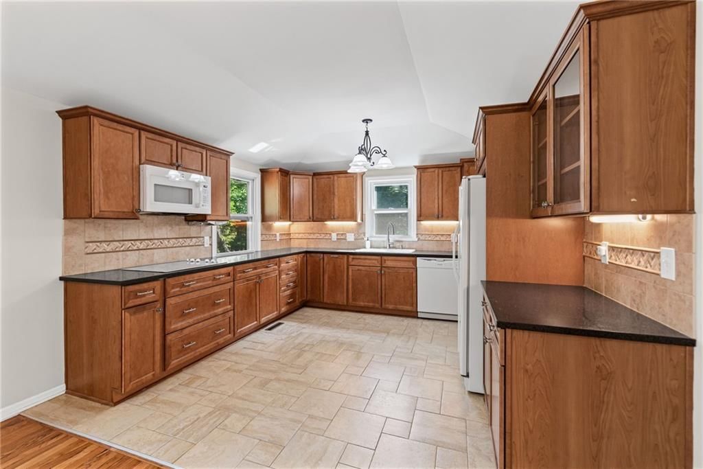 Wood kitchen cabinets, white appliances and electric range at 4516 NW Gleason Road, Kansas City, MO 64151