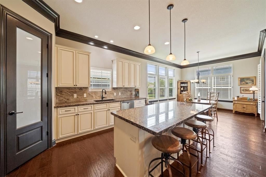 Statement lighting, kitchen island and granite counters at 3111 N 118TH Terrace, Kansas City, KS 66109
