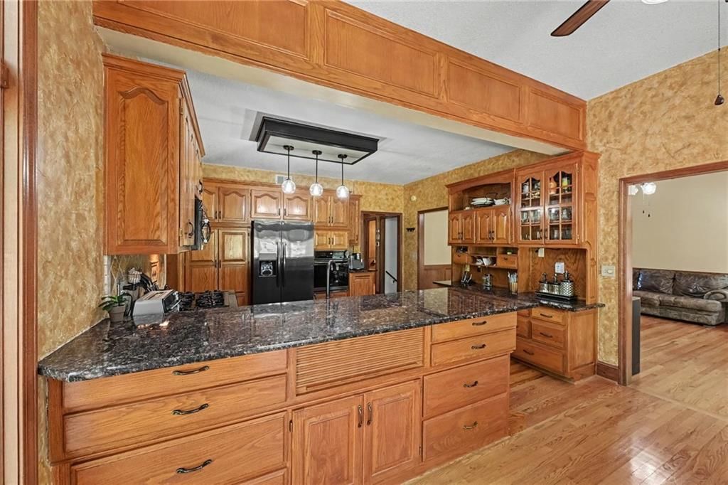 Kitchen island, granite counters and gas range at 8225 NW Weatherby Drive, Weatherby Lake, MO 64152