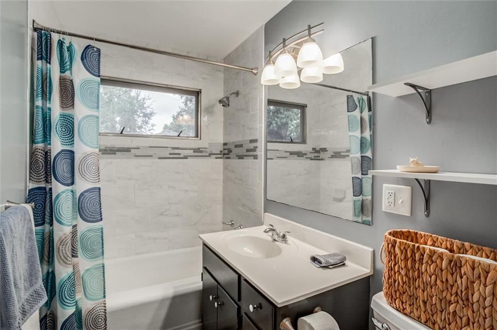 Tiled shower, frameless glass shower and wood vanity at 1025 E Elm Street, Olathe, KS 66061