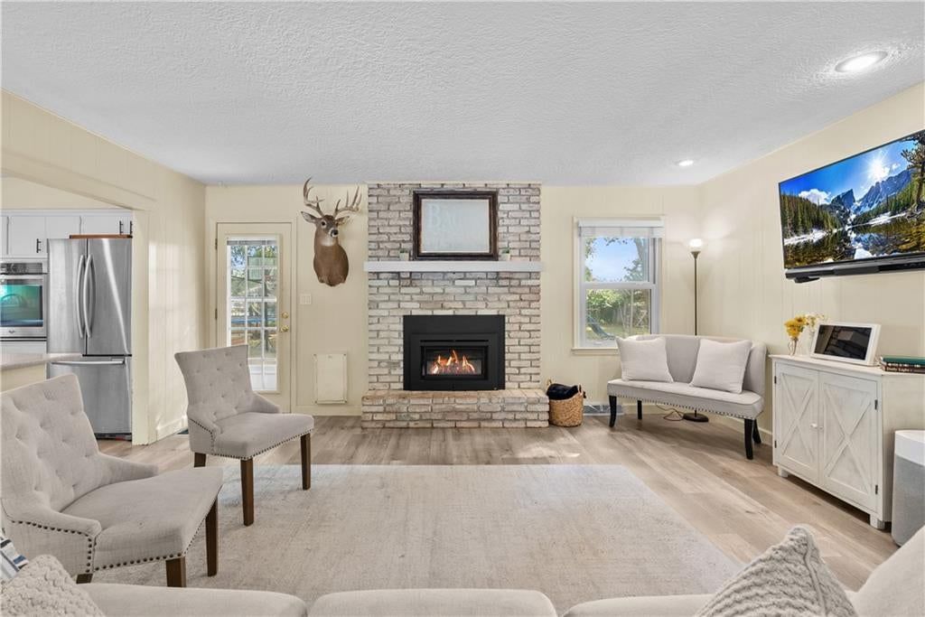 Fireplace, open floor plan and exposed brick wall at 105 Tuscarora Lane, Lake Winnebago, MO 64034
