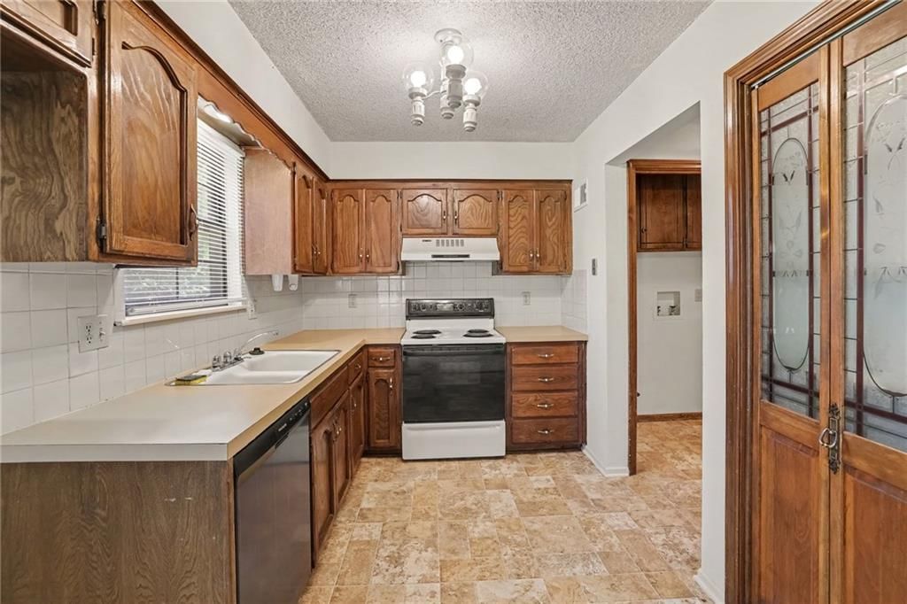 Wood kitchen cabinets, electric range and kitchen backsplash at 7507 Long Avenue, Lenexa, KS 66216