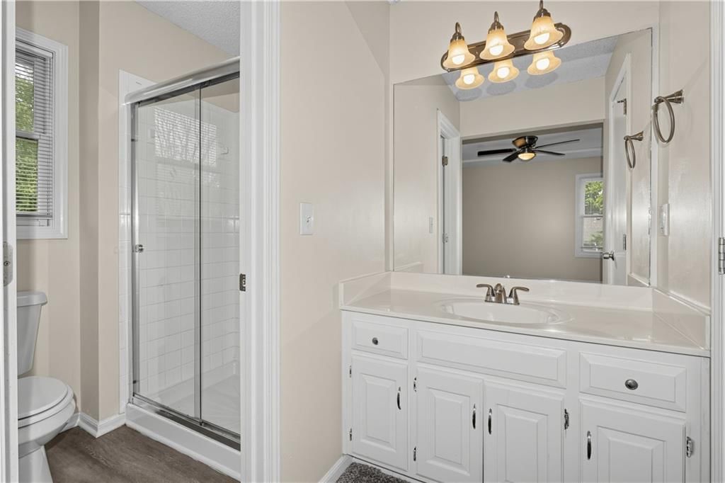 Statement lighting, tiled shower and double vanity at 2129 Sunset Circle, Pleasant Hill, MO 64080