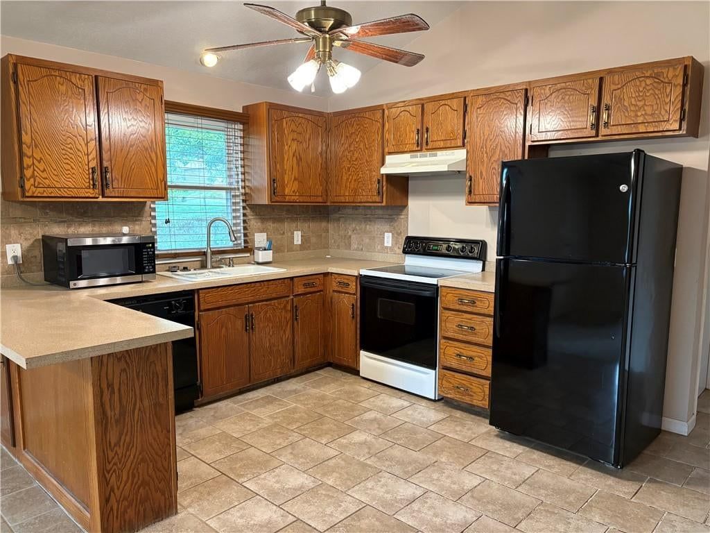 Wood kitchen cabinets, electric range and beige or brown countertops at 1224 Kingman Street, Leavenworth, KS 66048